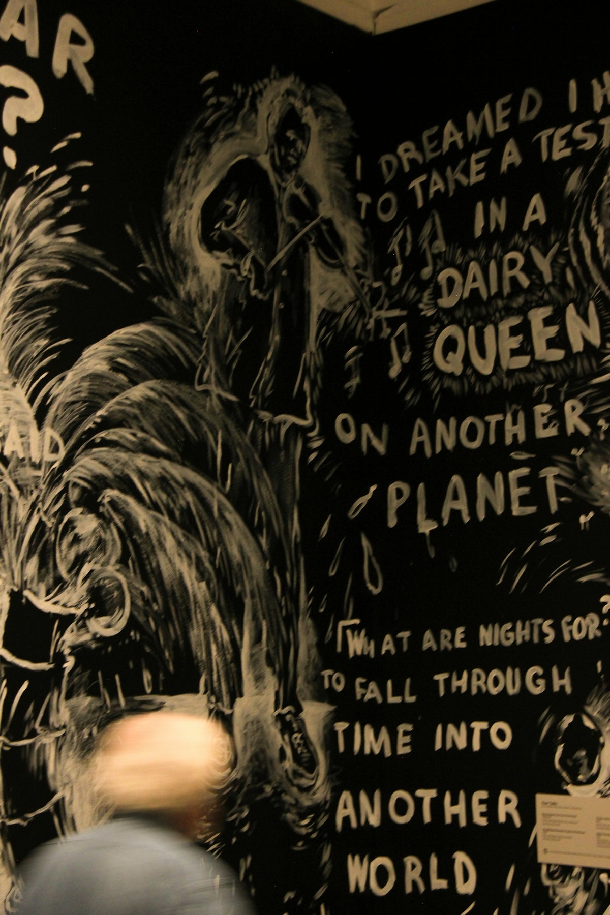 A man standing in front of a black and white wall