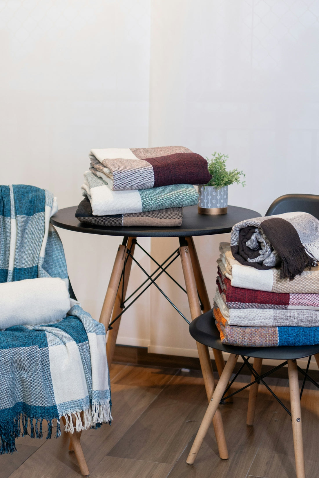A stack of blankets sitting on top of a table next to a chair