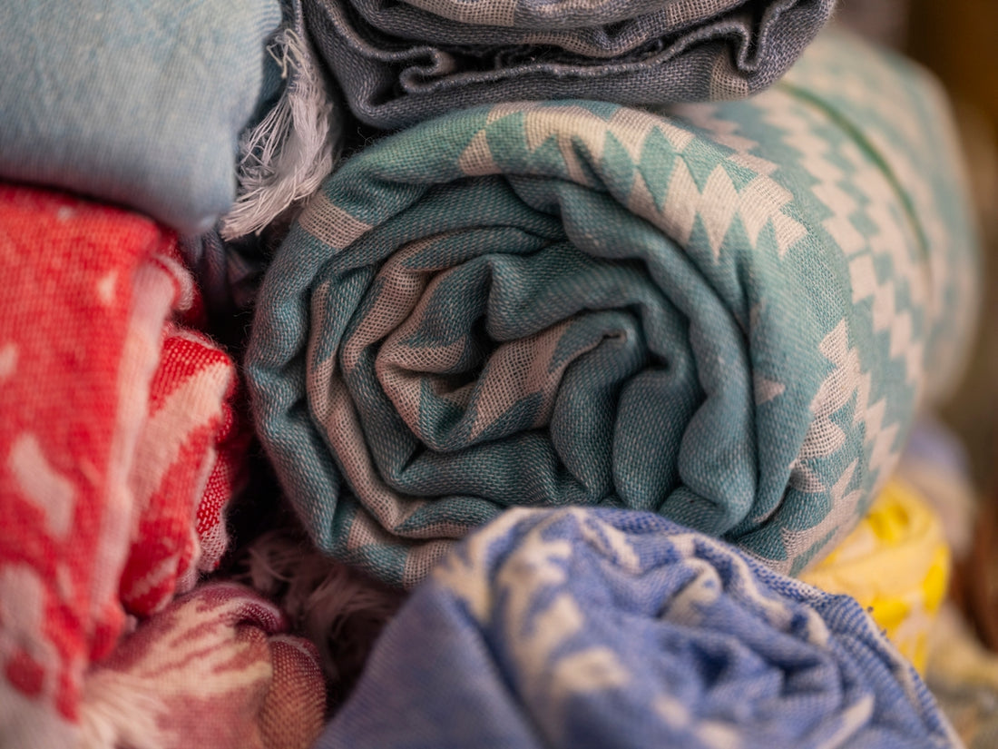 Rolled towels with colorful patterns stacked together.