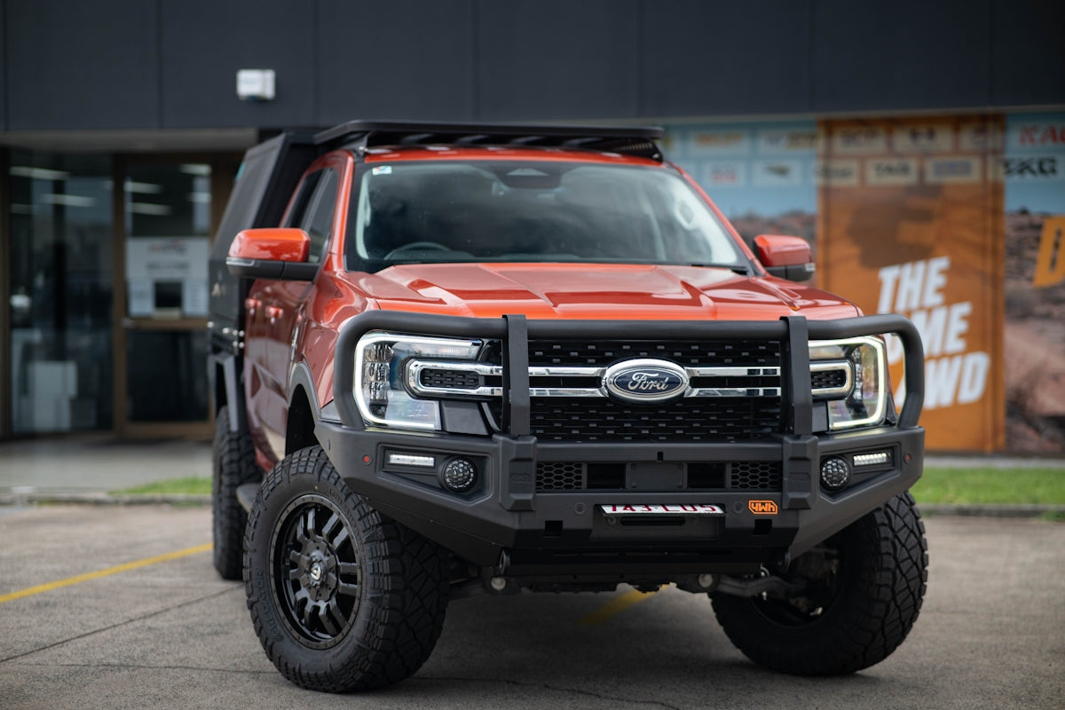 Orange ford truck with bull bar and roof rack